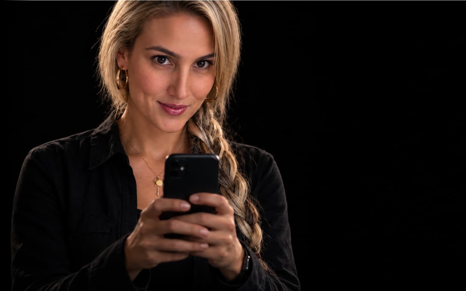 Sarita mirando a cámara con su celular